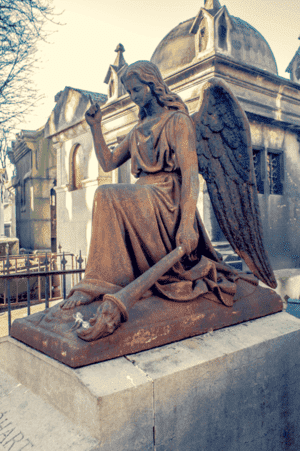 Tombe avec une statue d'ange à genoux